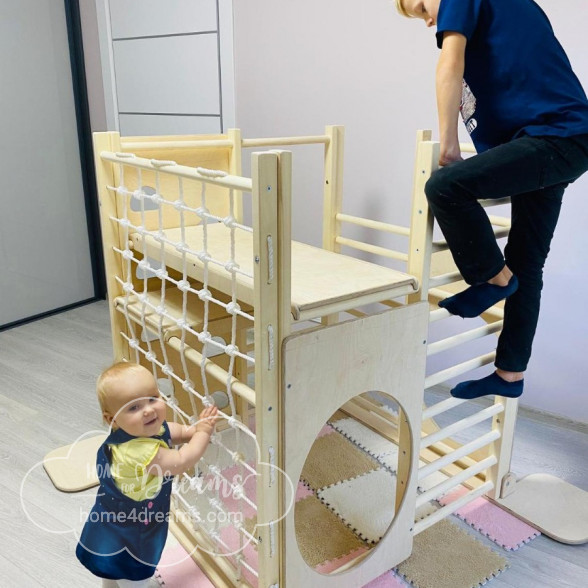 A boy and a toddler climbing on a play gym