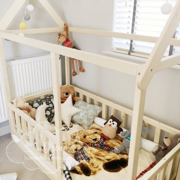 A Montessori house bed with toys placed on the mattress 