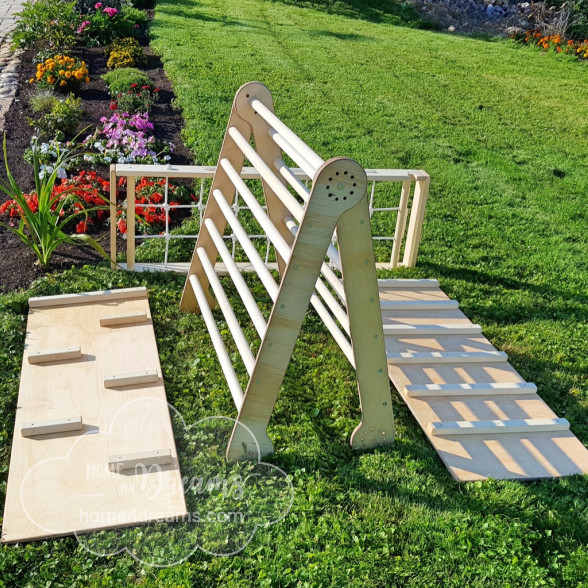 A wooden climbing pikler triangle with a slide board and other accessories