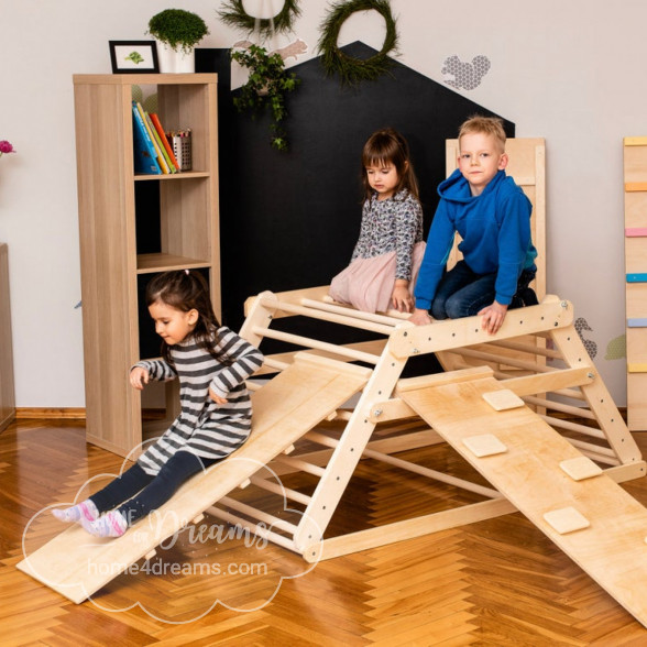 Children playing on an indoor climbing frame with slide and ladder boards