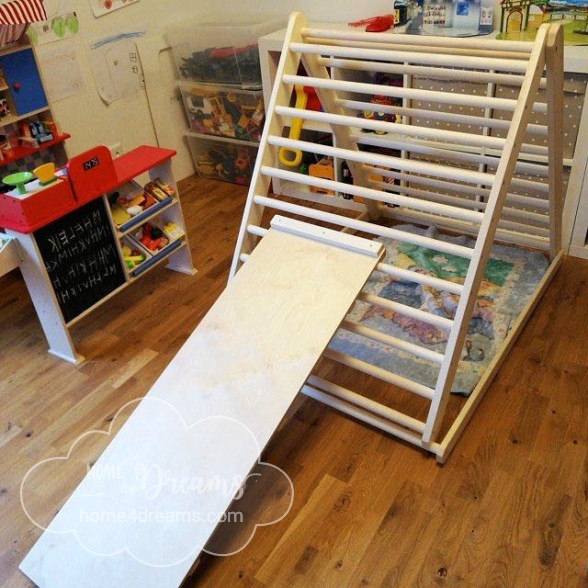 A children’s wooden climbing frame with a slide board