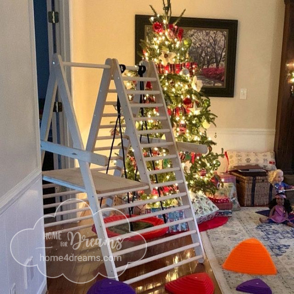 A climbing ladder for toddlers next to a Christmas tree