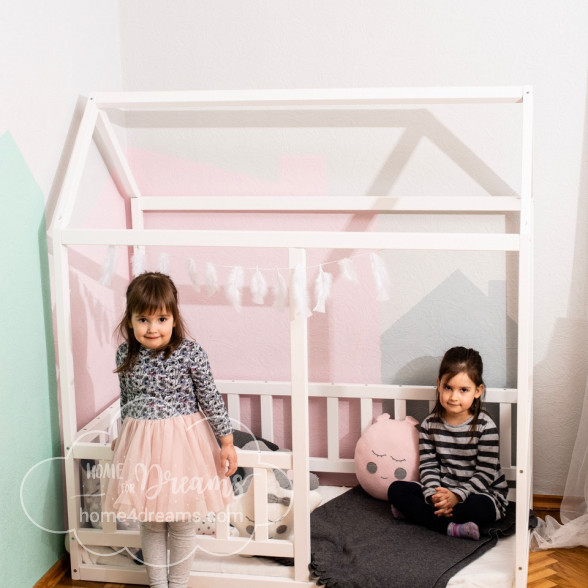 Two girls playing in a painted toddler bed