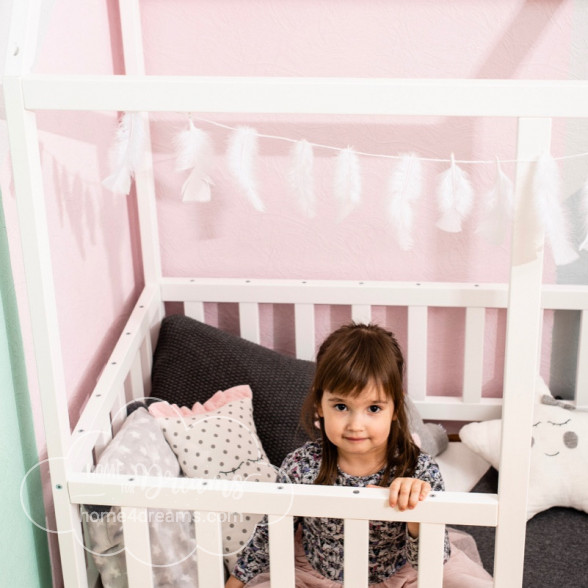 A child inside of a toddler house bed